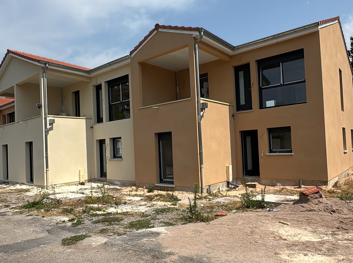 Logements accolés en enduit gratté, une partie ocre et une partie jaune clair